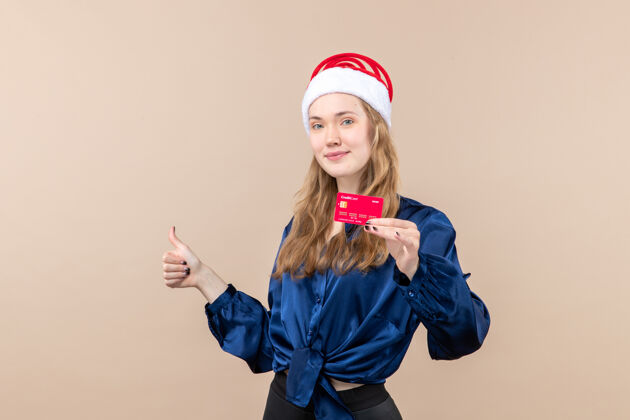 女性正面图年轻女子手持红色银行卡放在粉色办公桌上度假合影贺岁钱感慨人银行钱