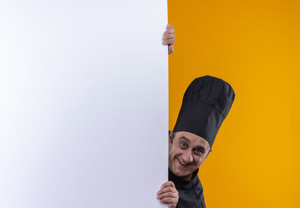 男微笑的中年男厨师 身着厨师制服 手持白色墙壁 背景为黄色 有复印空间持有中年厨师