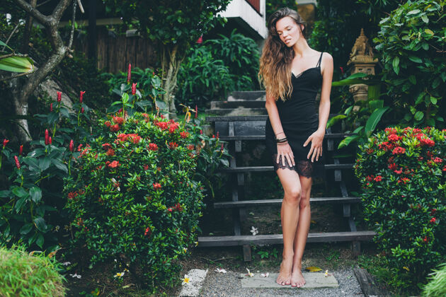 服装热带花园里年轻漂亮性感的女人 在泰国度暑假 苗条瘦削的棕褐色身材 带蕾丝的小黑裙 自然的造型 感性的 放松的 模特热带女人