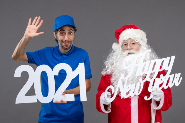 服装圣诞老人与男信使举行和新年快乐和2021年板灰墙的正面视图男人肖像快乐