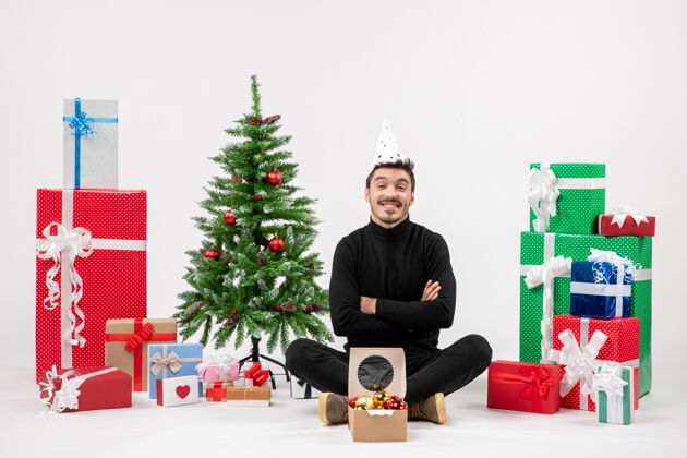礼物年轻人围坐在节日礼物旁 微笑着站在白色的墙上盒子寒冷节日