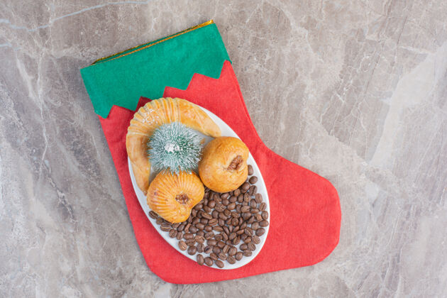 美味放在大理石上的圣诞袜子上的节日小点心盘商品咖啡圣诞节