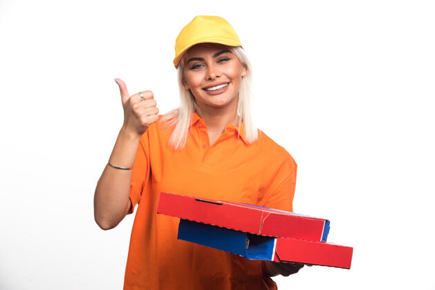 女孩披萨送货员拿着白色背景的披萨 竖起大拇指高质量的照片披萨用餐人