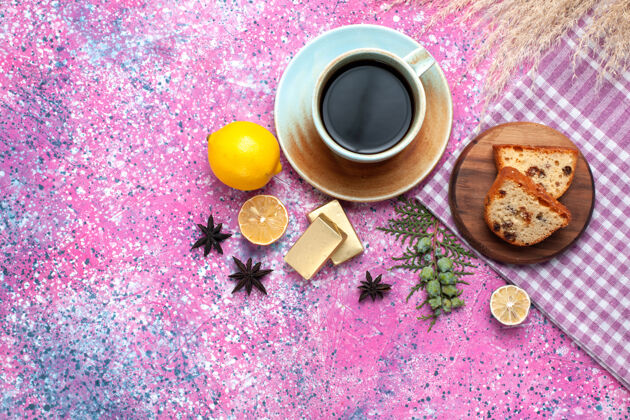 采购产品蛋糕在浅粉色的表面上用一杯茶和柠檬切片的美味蛋糕俯视图面团茶馅饼