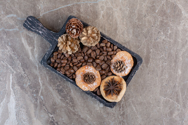 美味美味的饼干茴香 咖啡豆和松果放在大理石上视图针叶树顶部