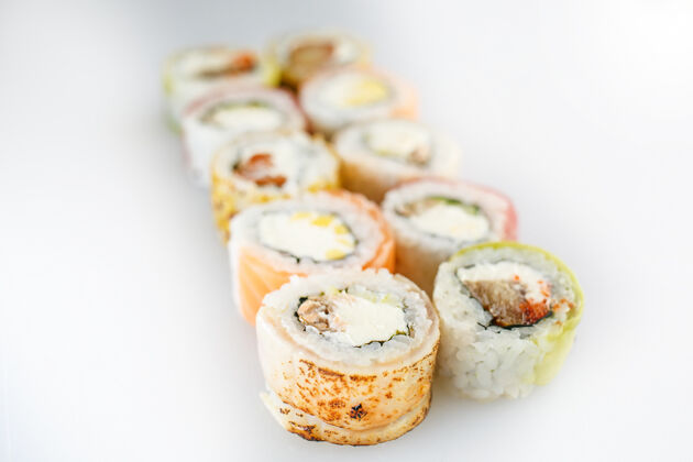 卷寿司套餐三文鱼和蔬菜卷 素食者 放在白色表面的木盘上准备亚洲小吃