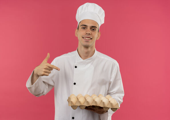 厨师面带微笑的年轻男厨师身穿厨师制服 指着手指向手中的一批鸡蛋复印空间手指手鸡蛋