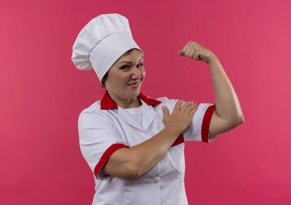 中年微笑的中年女厨师身着厨师制服做着坚强的手势动作女厨师