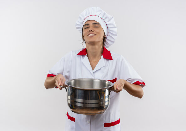穿着压力大的年轻女厨师穿着厨师制服拿着沉重的平底锅和复印空间厨师厨师女