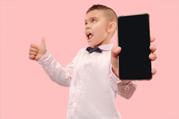 手室内肖像的迷人的年轻男孩拿着空白的智能手机通信手机智能手机