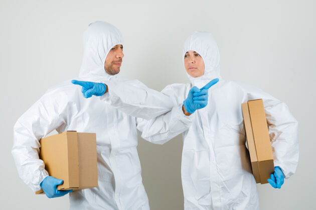 妇女两个医生穿着防护服 戴着手套拿着纸板箱女性健康年轻