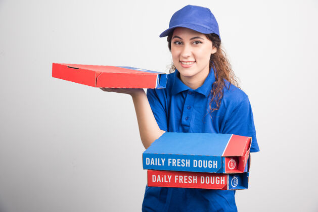 披萨送比萨饼的女孩拿着三个白色背景的盒子高质量的照片送货食物帽子