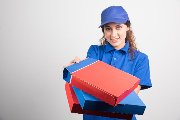持有送比萨饼的女孩拿着三个白色背景的盒子高质量的照片美味披萨工人