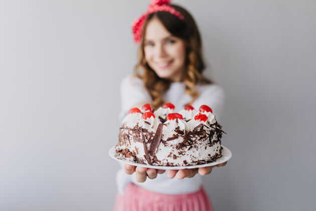 吃精致的白种女人展示美味的蛋糕和浆果室内肖像令人惊叹的生日女孩与奶油派自制情感表情