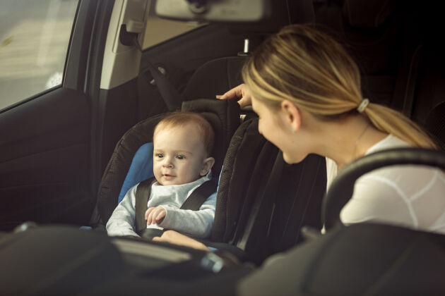 安全带母亲和男婴坐在汽车前排座位上的色调肖像肖像父母小