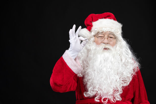 肖像圣诞老人穿着经典的红色套装 黑墙上留着白胡子的正面图正面快乐胡须