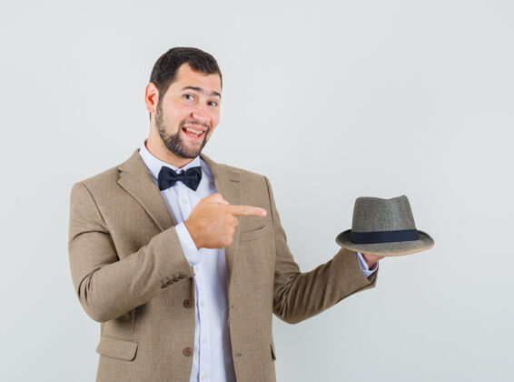 肖像一个穿着西装的年轻人指着帽子 看上去很高兴 正对着窗外友好帽子快乐