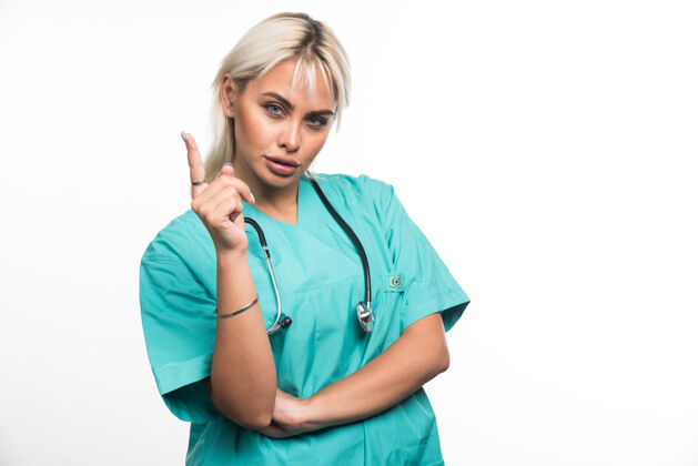 护理女医生用听诊器指着白色背景上的手指高品质的照片女性人类工作