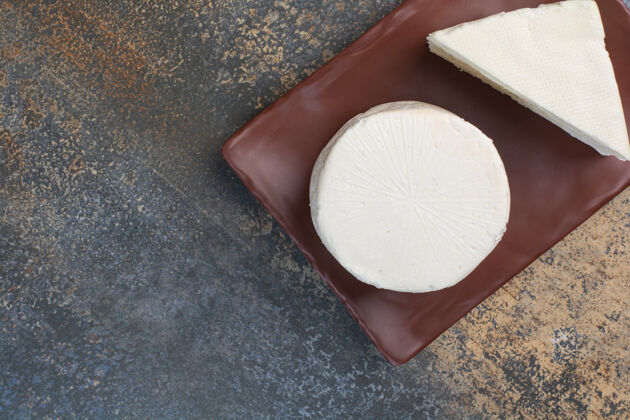 乳制品白芝士 切片放在棕色盘子里美味奶酪开胃菜