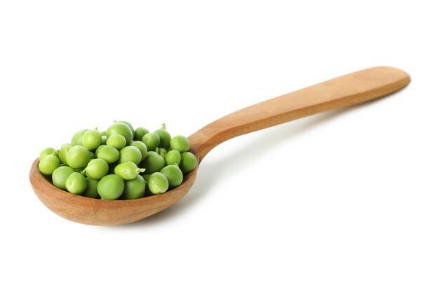 素食者把豌豆籽放在白色的勺子里小吃豆类物体
