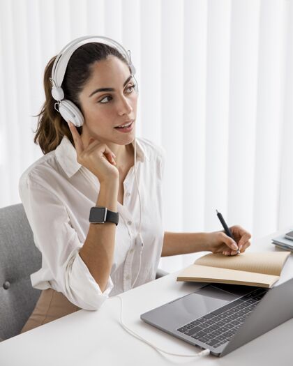 精致优雅的女商人使用笔记本电脑和耳机优雅个性女士