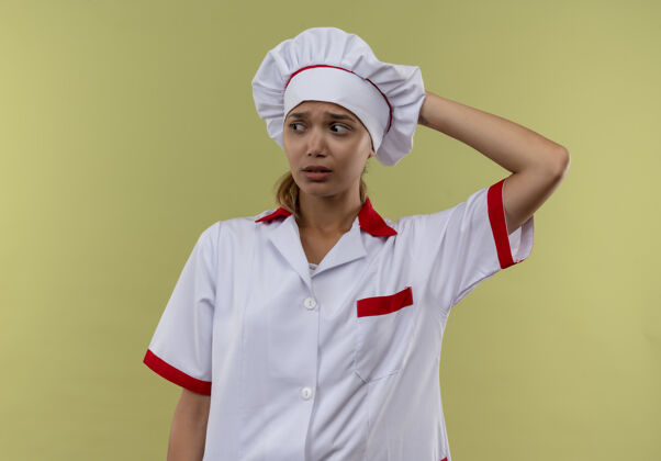 手看着身边迷茫的年轻厨师女 穿着厨师制服 手放在头上 隔着一堵绿墙 留着临摹的空间放年轻制服