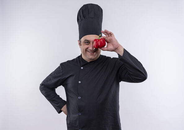 厨师身着厨师制服的中年男厨师微笑着用胡椒粉捂住眼睛 把手放在臀部臀厨师中年