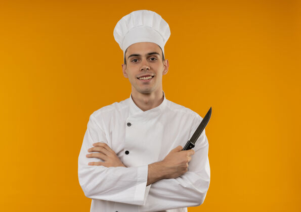 制服笑容可掬的男青年酷穿厨师制服双手交叉持刀与复印空间交叉厨师手