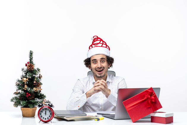 满意满意忙碌自豪的年轻商人与有趣的圣诞老人帽子庆祝圣诞节在白色背景的办公室圣诞老人庆祝帽子