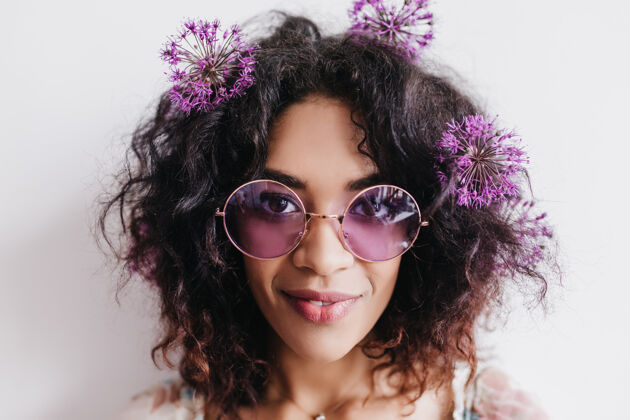 肖像快乐的非洲女人头发上摆着鲜花的特写照片戴着太阳镜的快乐黑人女孩的室内肖像年轻休闲积极