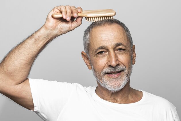 老年人特写男人刷他的头发护理养老金领取者男性