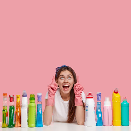 惊奇快乐主妇垂直镜头 正面惊呼 戴橡胶防护手套 为你的广告指向上洗涤剂卫生家务