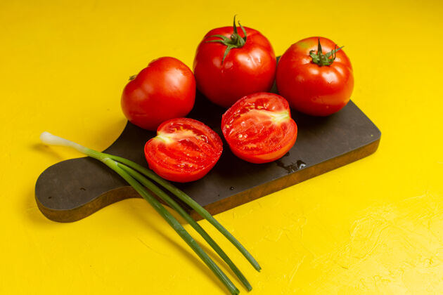 蔬菜黄色墙壁上新鲜的红色西红柿和洋葱的正面视图洋葱配料新鲜