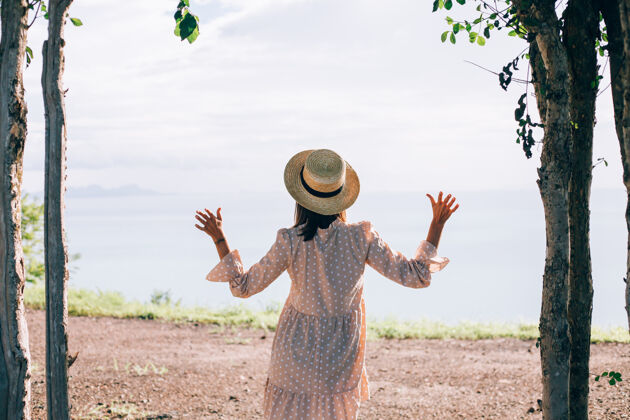 欢乐快乐的女人在夏天可爱的裙子和草帽度假与热带异国情调的看法享受度假休息