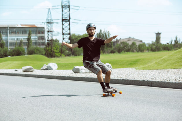 沥青在阳光明媚的日子里 滑板运动员在城市的街道上玩花样跳跃男孩把戏