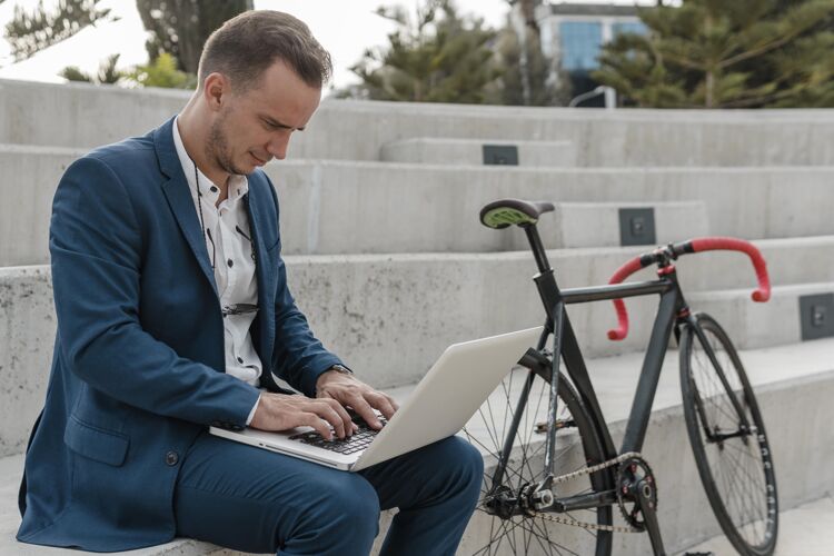 骑自行车的在户外骑自行车的人在笔记本电脑上工作运动的骑自行车休息