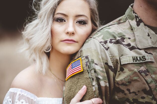 妻子浅浅的焦点是一个迷人的女性握着美国士兵的手臂保护者战士爱情