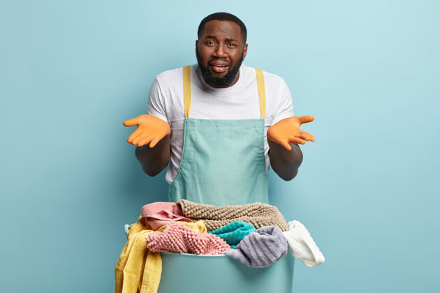 成人年轻的非洲裔美国人在洗衣服毛巾篮子人