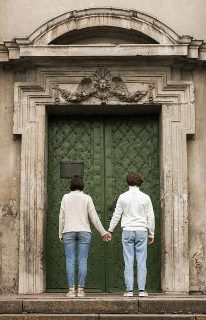 现代一对年轻夫妇在门前摆姿势青年成人城市