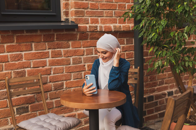 年轻快乐的穆斯林妇女在城市里用智能手机进行视频通话穆斯林团队阿拉伯语