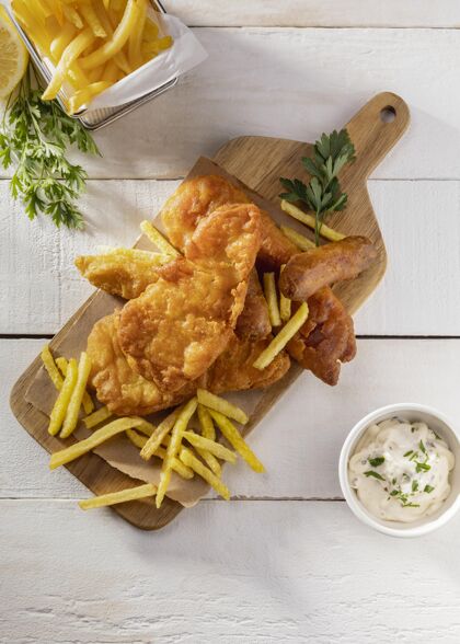 美味切菜板上的炸鱼和薯条的顶视图平平放食物